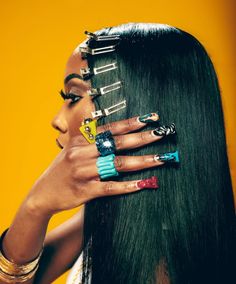 a woman with long black hair and rings on her fingers