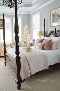 a bedroom with a canopy bed, chandelier and christmas tree in the corner