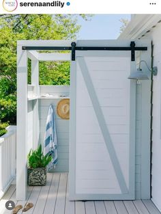 an open door on the side of a white house with a blue towel hanging from it