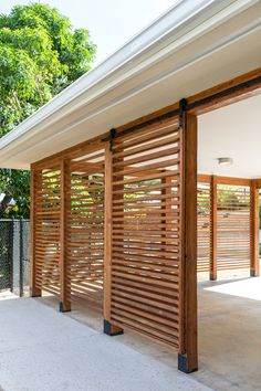 an open garage door with wooden slats on the sides and side walk leading up to it