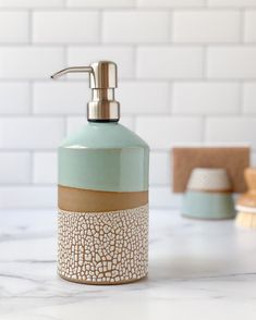 a soap dispenser sitting on top of a counter next to a toothbrush holder