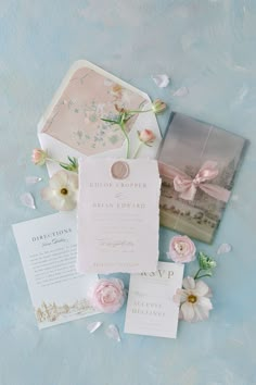 the wedding stationery is laid out with flowers