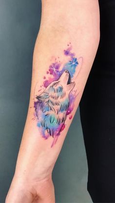 a woman's arm with a wolf tattoo on it