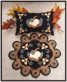 two decorative pillows on the floor with autumn leaves