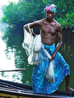 a man standing on top of a boat in the middle of a river with nets