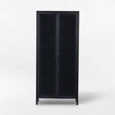 a tall black cabinet sitting on top of a white floor