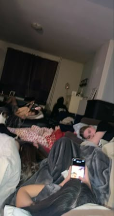 a group of people laying on top of a bed in a living room next to each other