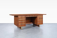 an old wooden desk with drawers on the top and bottom, in front of a white wall