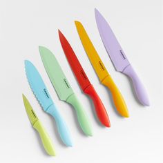 five different colored knives are lined up in a row