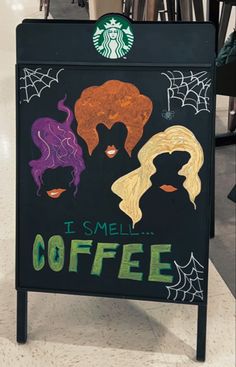 a sign that says it smell coffee with two women's faces painted on it