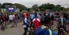 a large group of bicyclists are riding down the street in front of spectators