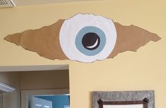 an eyeball on the wall next to a sign