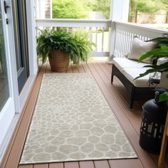 a porch with a rug and potted plants on it