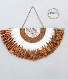 a white and brown wall hanging with fringes