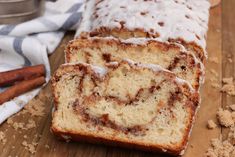 two slices of cinnamon swirl bread on a cutting board with cinnamon sticks next to it