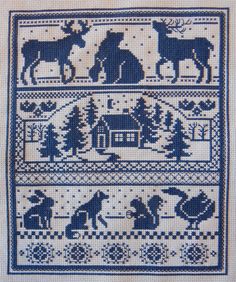 a blue and white cross - stitch pattern with animals, trees, and people on it