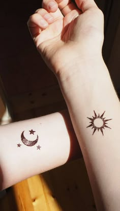 two wrist tattoos with stars and moon on each one side of the arm, both in black ink