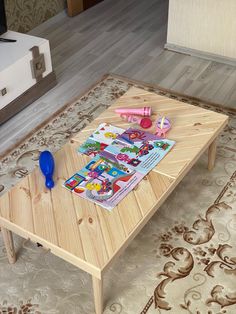 a wooden coffee table with magazines and toys on it