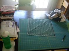 the table is covered with cloths and other items for making quilts on it