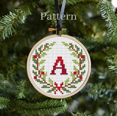 a cross stitch ornament hanging from a christmas tree with the letter a on it