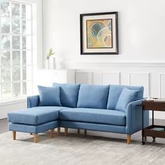 a living room with a blue sectional couch and coffee table in front of a window