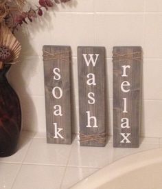 three wooden signs that spell out swash, sauerkah, and oak in front of a bathtub