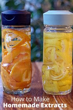 two jars filled with oranges sitting on top of a wooden table next to each other