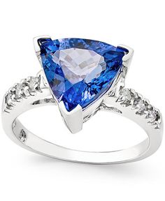 a white gold ring with a blue topazte and diamonds