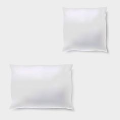 two white pillows sitting next to each other