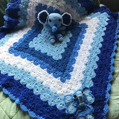 a crocheted blanket with an elephant on it and a stuffed animal in the middle