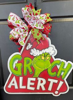 the grin alert door hanger is decorated with red, green and white bows