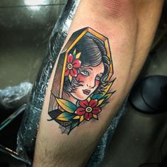 a woman's face with flowers and leaves on her arm