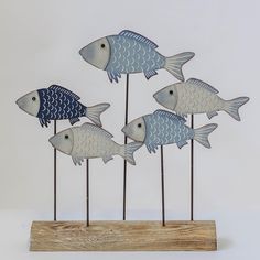 four blue and white fish on wooden sticks