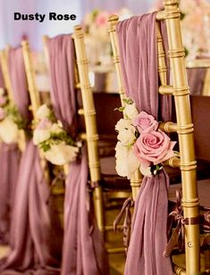 the chairs are lined up with purple drapes and pink flowers on each one side