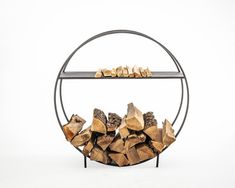 a stack of firewood sitting on top of a metal rack next to a white wall