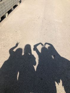 the shadow of two people standing next to each other in front of a parking lot