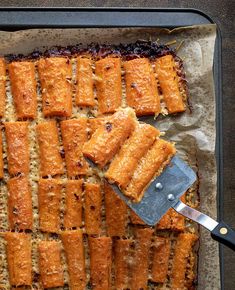 a pan filled with food next to a spatula