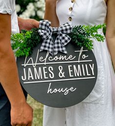 a man and woman holding a sign that says welcome to james & embly house