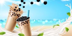 two cups filled with milk and blackberries next to each other on the sand near the ocean