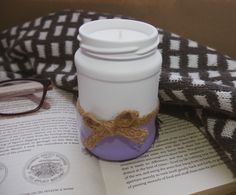 a coffee cup sitting on top of an open book next to a pair of glasses