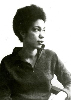 an old black and white photo of a woman with short hair wearing a sweater over her shoulders