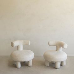 two white chairs sitting next to each other