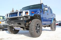 a blue hummer truck parked in the snow