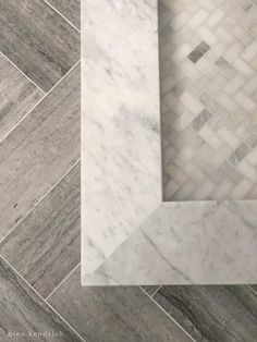 a white marble bathroom floor with herring tile