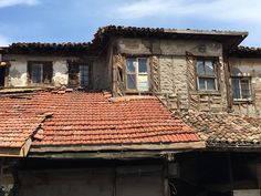 an old run down building with red tiled roofs