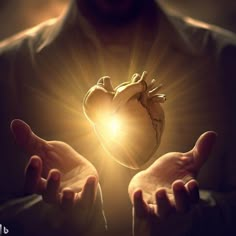 someone holding their hands in the shape of a heart with bright light coming from it