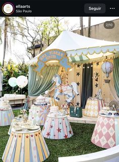 an elaborate carousel set up in the grass with balloons and other decorations on display behind it