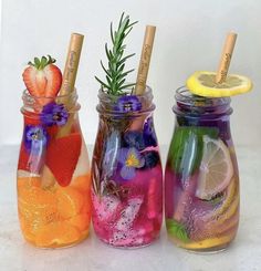 three mason jars filled with different colored drinks