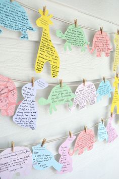 paper elephants are hung on clothes pins with handwritten notes attached to the pegs