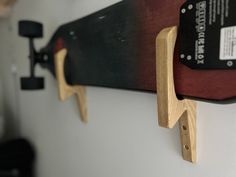 two skateboards mounted to the side of a wall with wooden brackets on it's sides